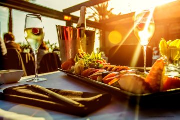 food and wine with a sunset behind it
